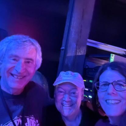 A group of people are posing for a picture in a dark room.