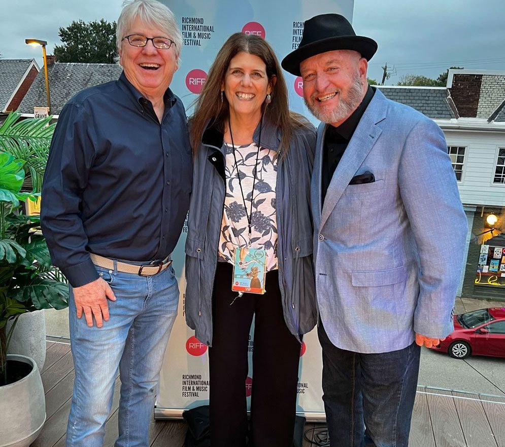 A group of people posing for a picture in front of a sign that says car show