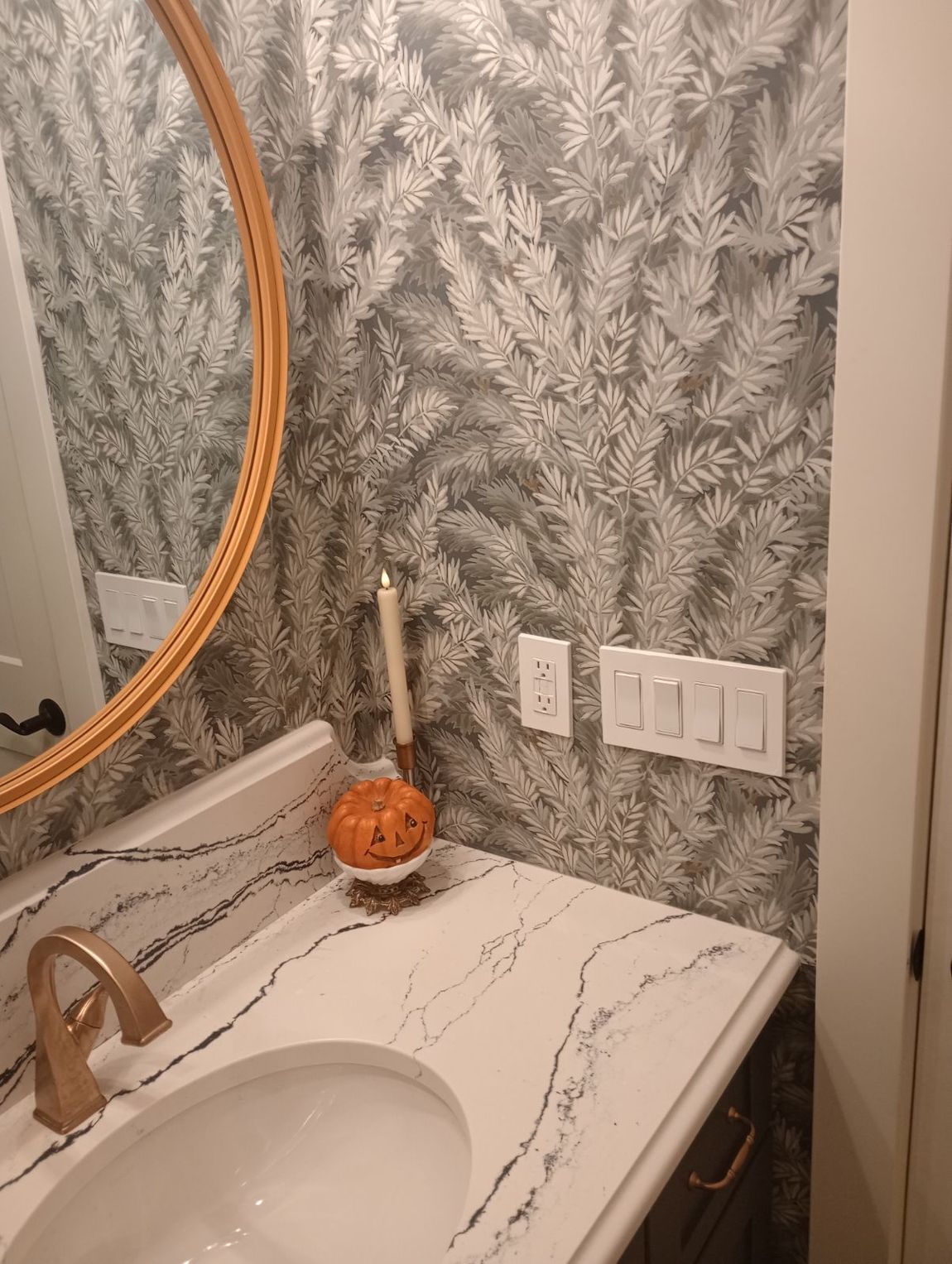 A bathroom with a sink , mirror , and candles.