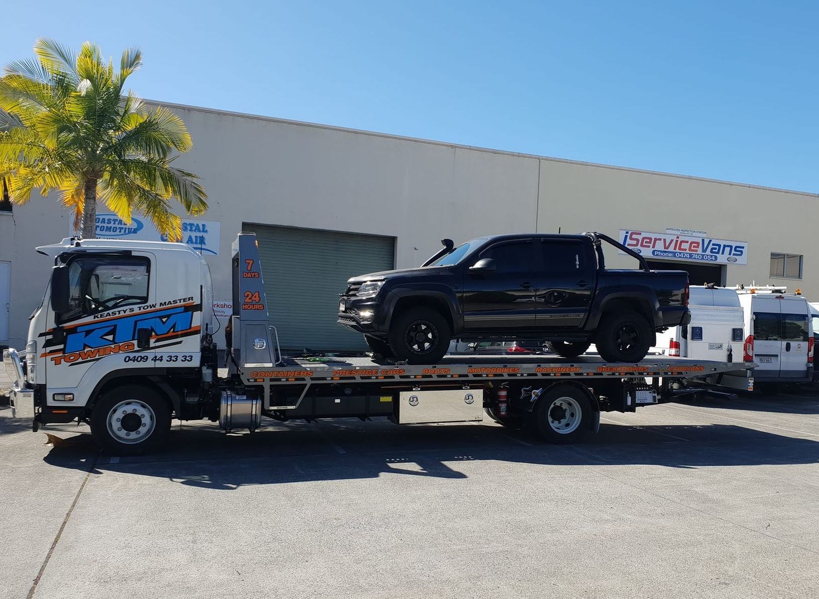 A Tow Truck With A Black Truck On The Back — KTM Towing In Kempsey, NSW