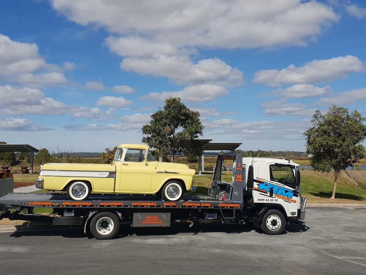 A Yellow Truck Is Being Towed By A Tow Truck — KTM Towing In Kempsey, NSW