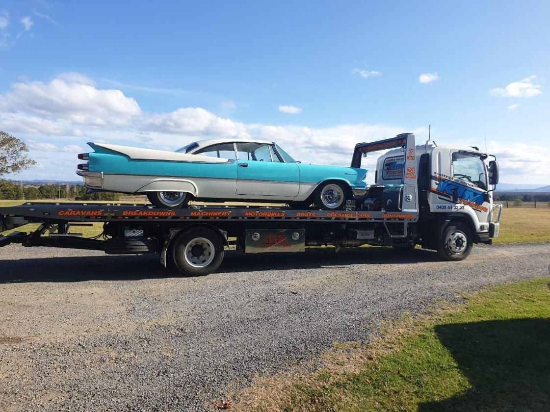 A Blue And White Car Is Being Towed By A Tow Truck — KTM Towing In Wauchope, NSW