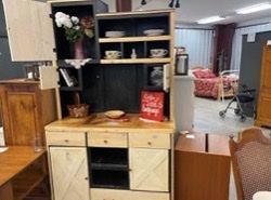A wooden cabinet with a lot of shelves and drawers in a room.