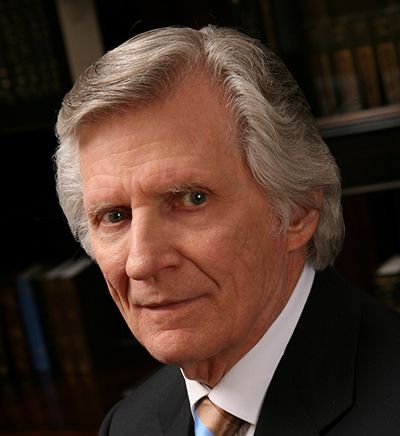 A man in a suit and tie is looking at the camera