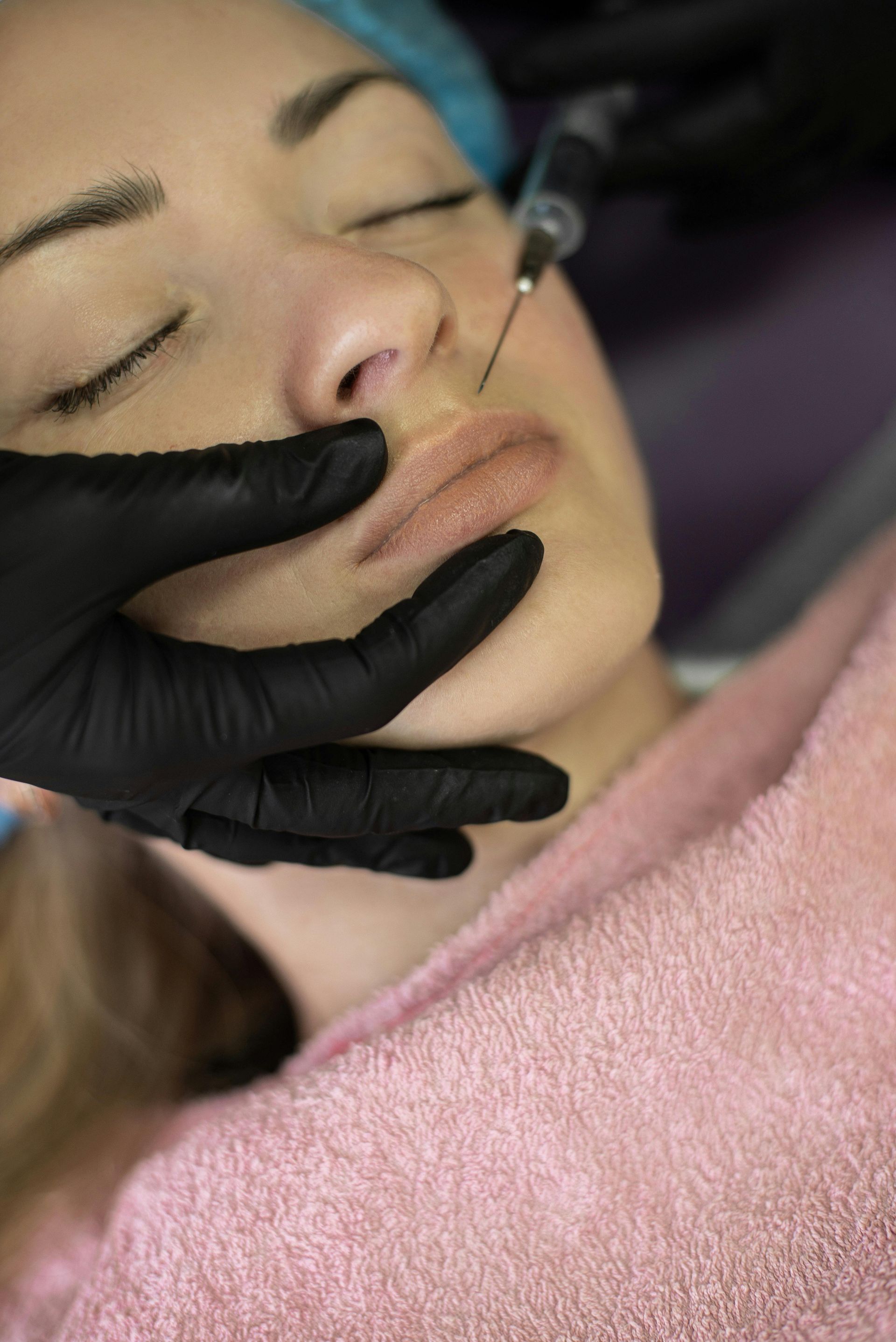 A woman is getting a botox injection in her face.