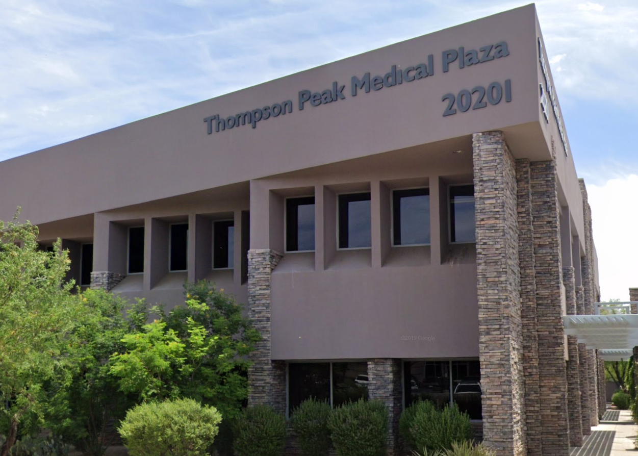 A large building with a parking lot in front of it.