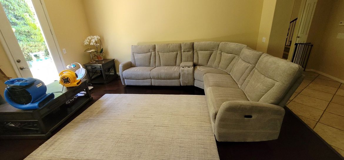 Living room with beige sectional sofa, cream rug, and a sliding glass door on the left