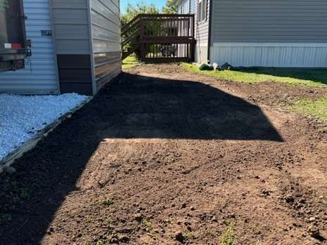 A dirt road leading to a mobile home.