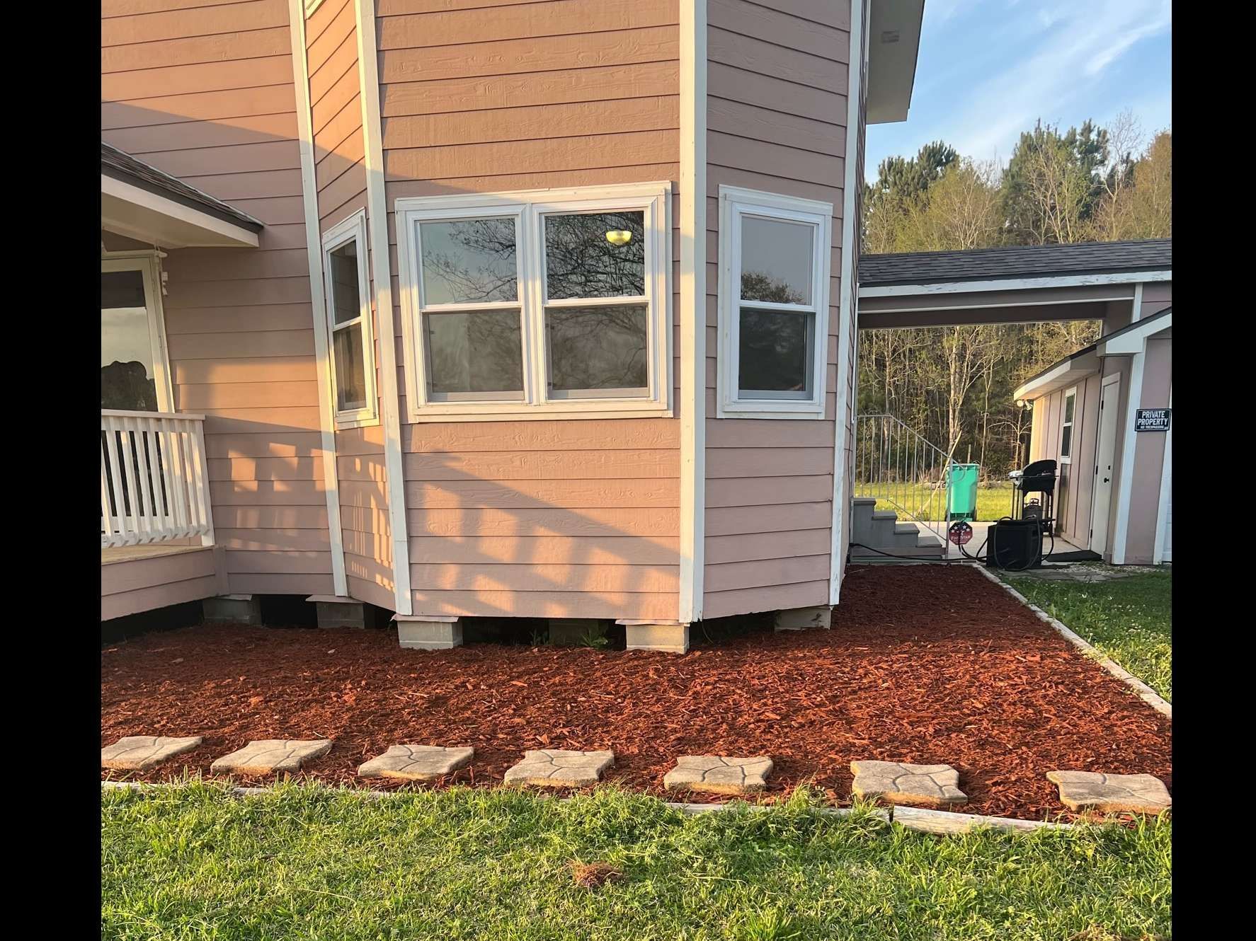 A pink house with a lot of windows and a walkway in front of it.