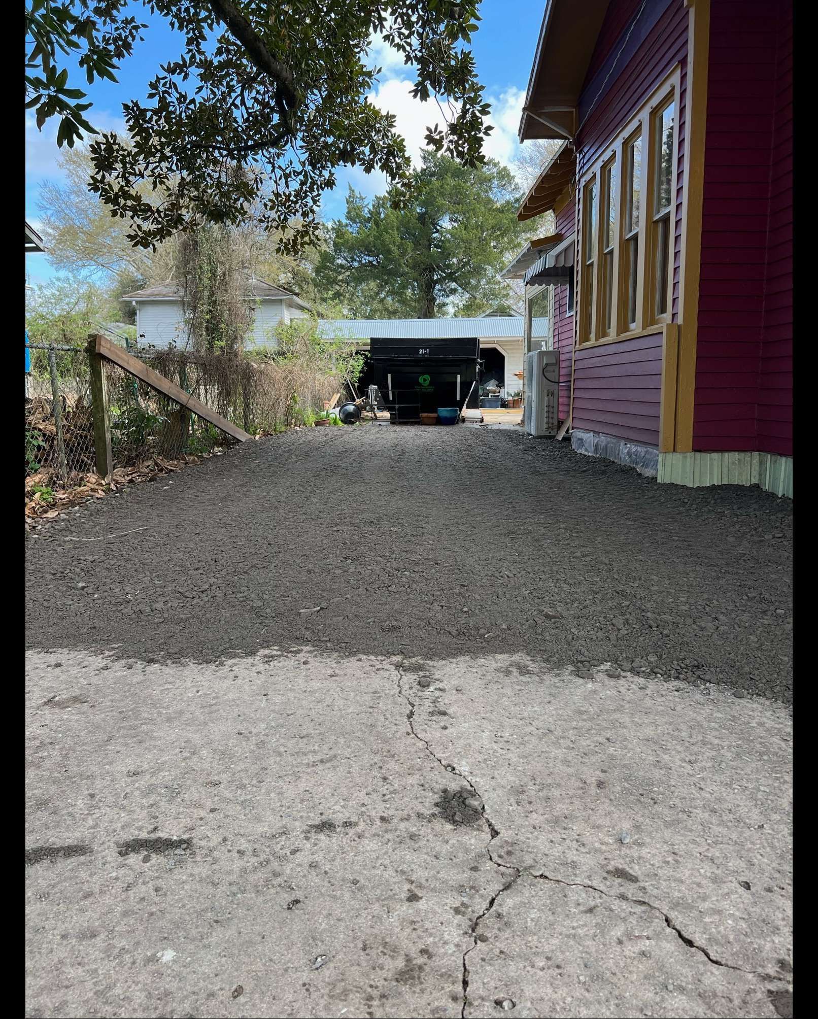 A red house with a black trailer parked in front of it.