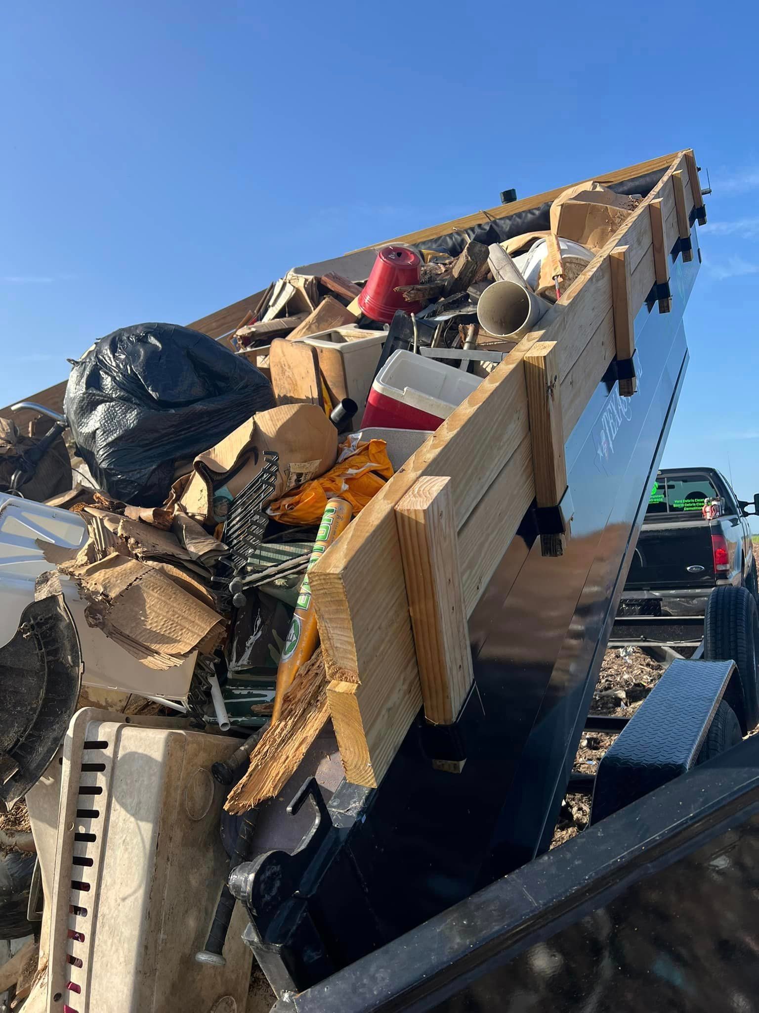 A pile of trash is sitting in the back of a truck.