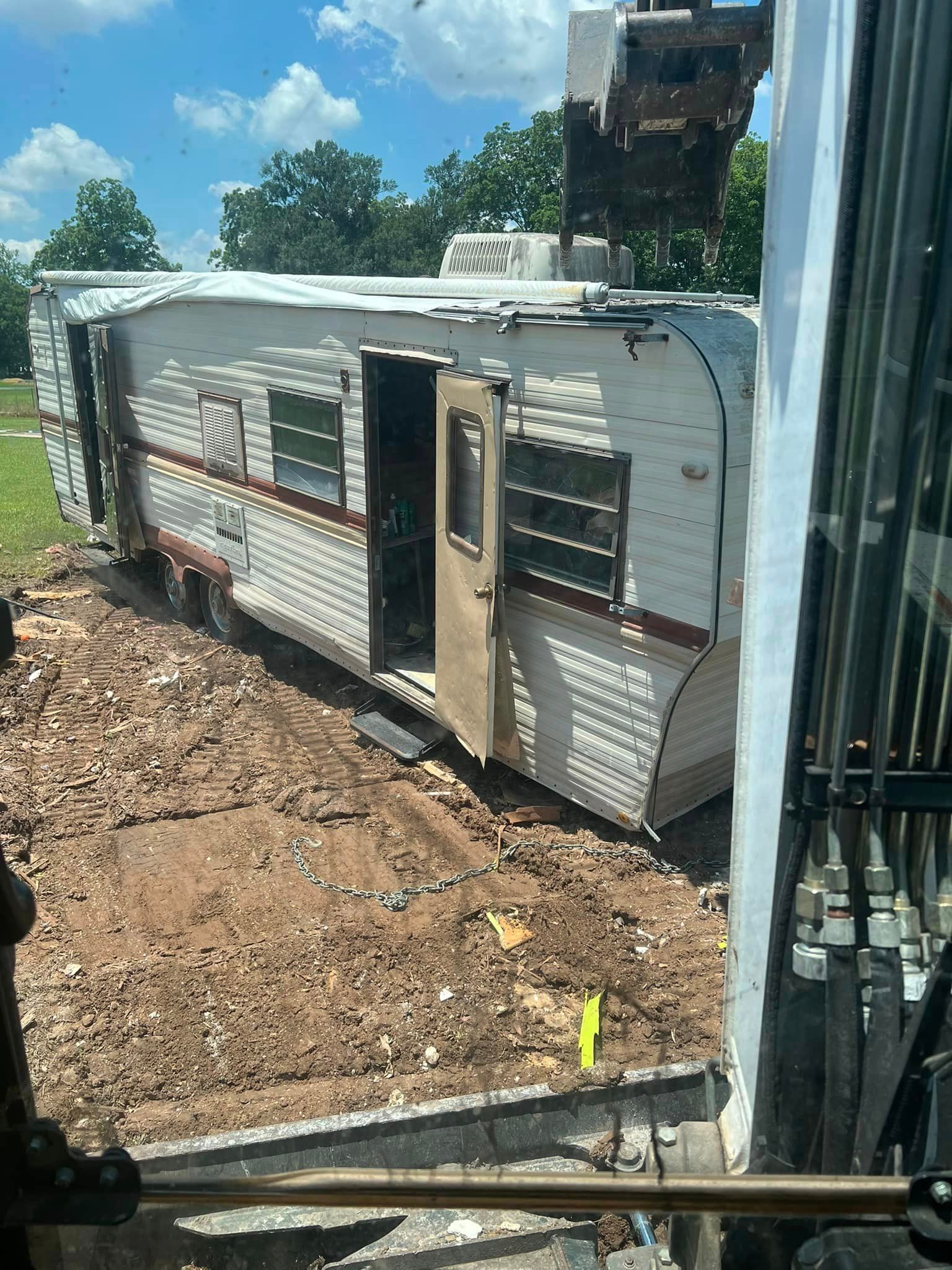A trailer is sitting on top of a dirt field.