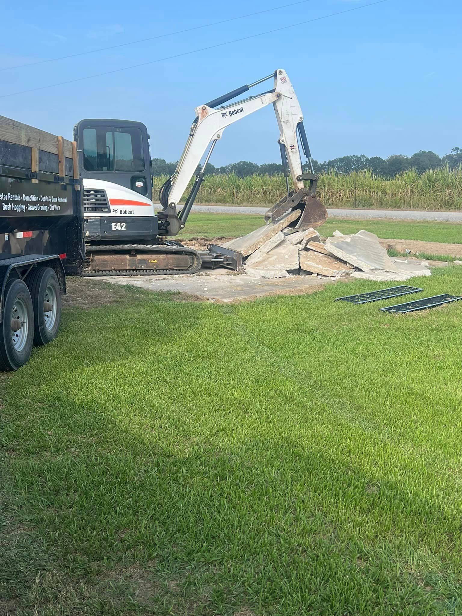 A bulldozer is digging a hole in a grassy field.