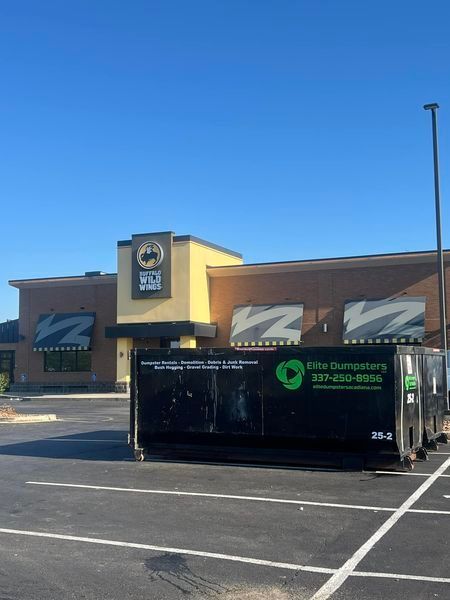 A dumpster is parked in front of a building that says free dumpsters