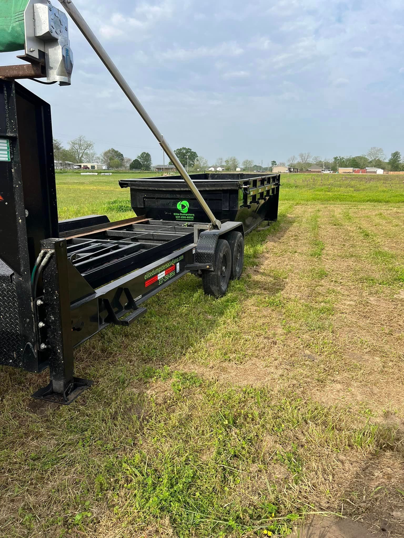 A trailer is parked in the middle of a grassy field.