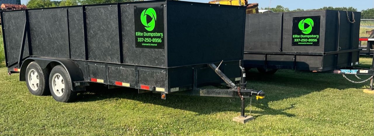 Two dumpsters are parked next to each other in a grassy field.