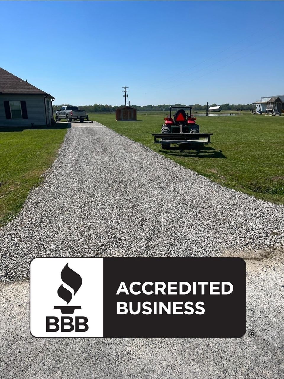 A gravel driveway with a sign that says accredited business