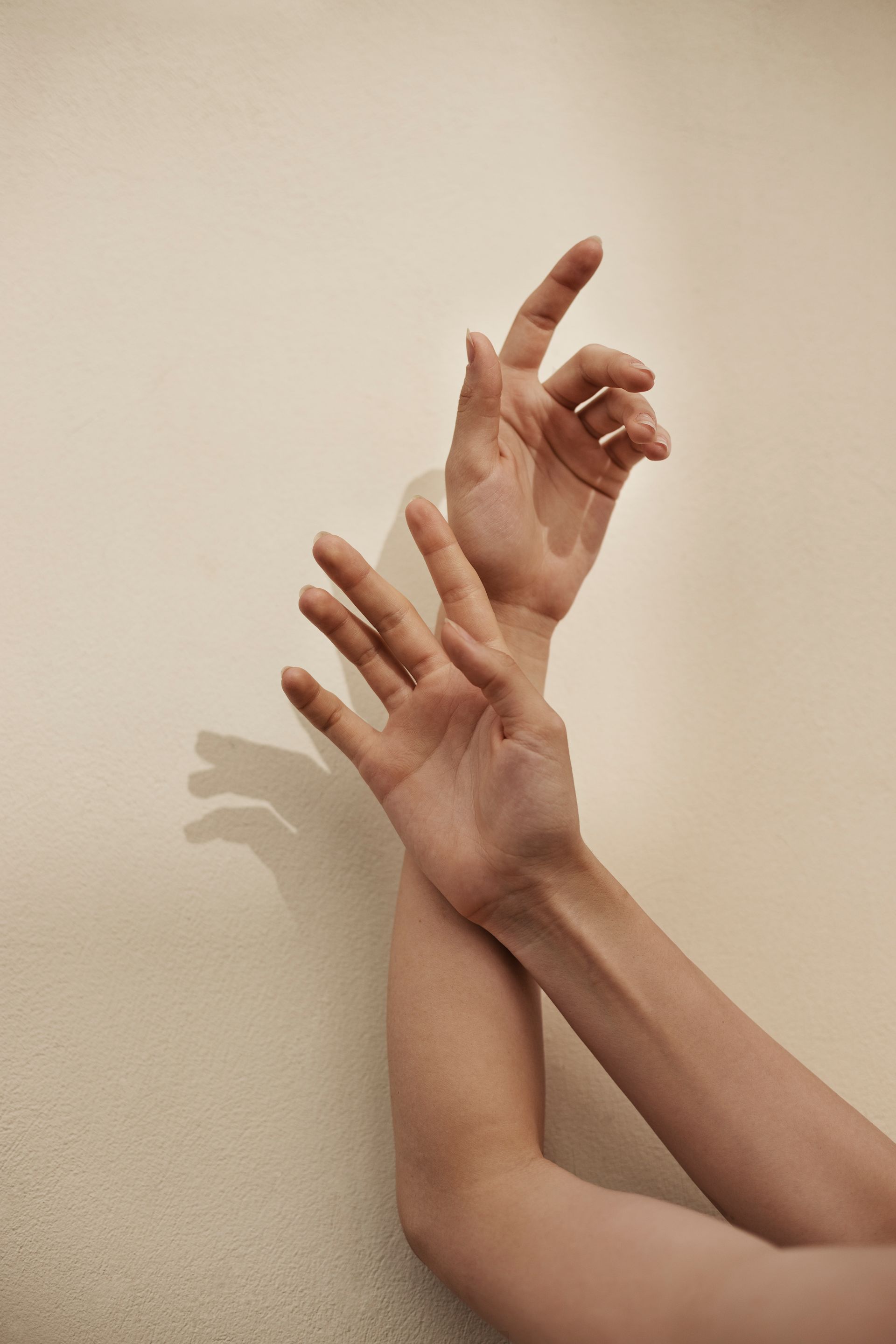 A close up of a person 's hands against a white wall.