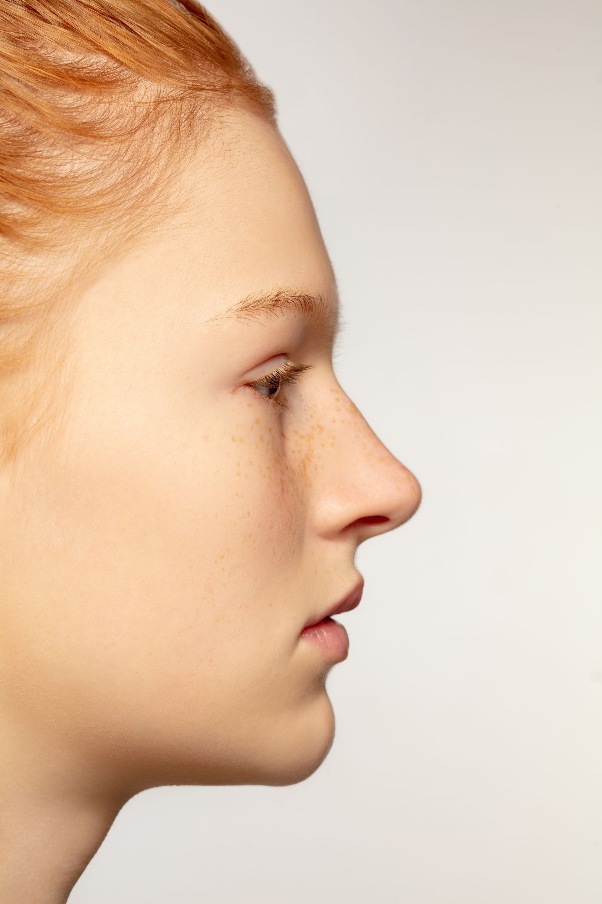A close up of a woman 's face with red hair and freckles.