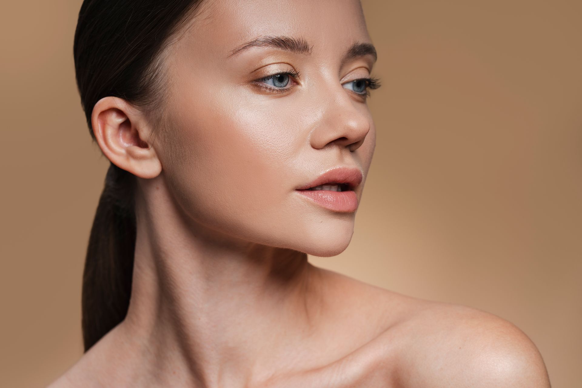 A close up of a woman 's face with a ponytail.