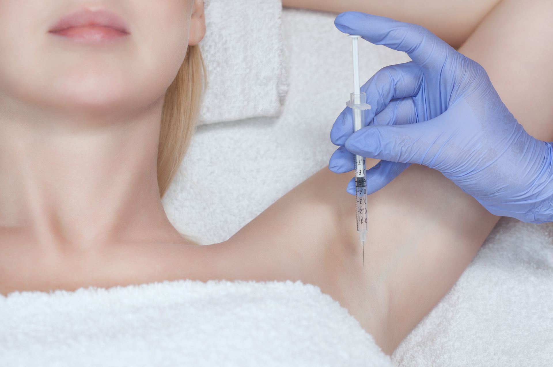 a woman is getting an injection in her armpit .