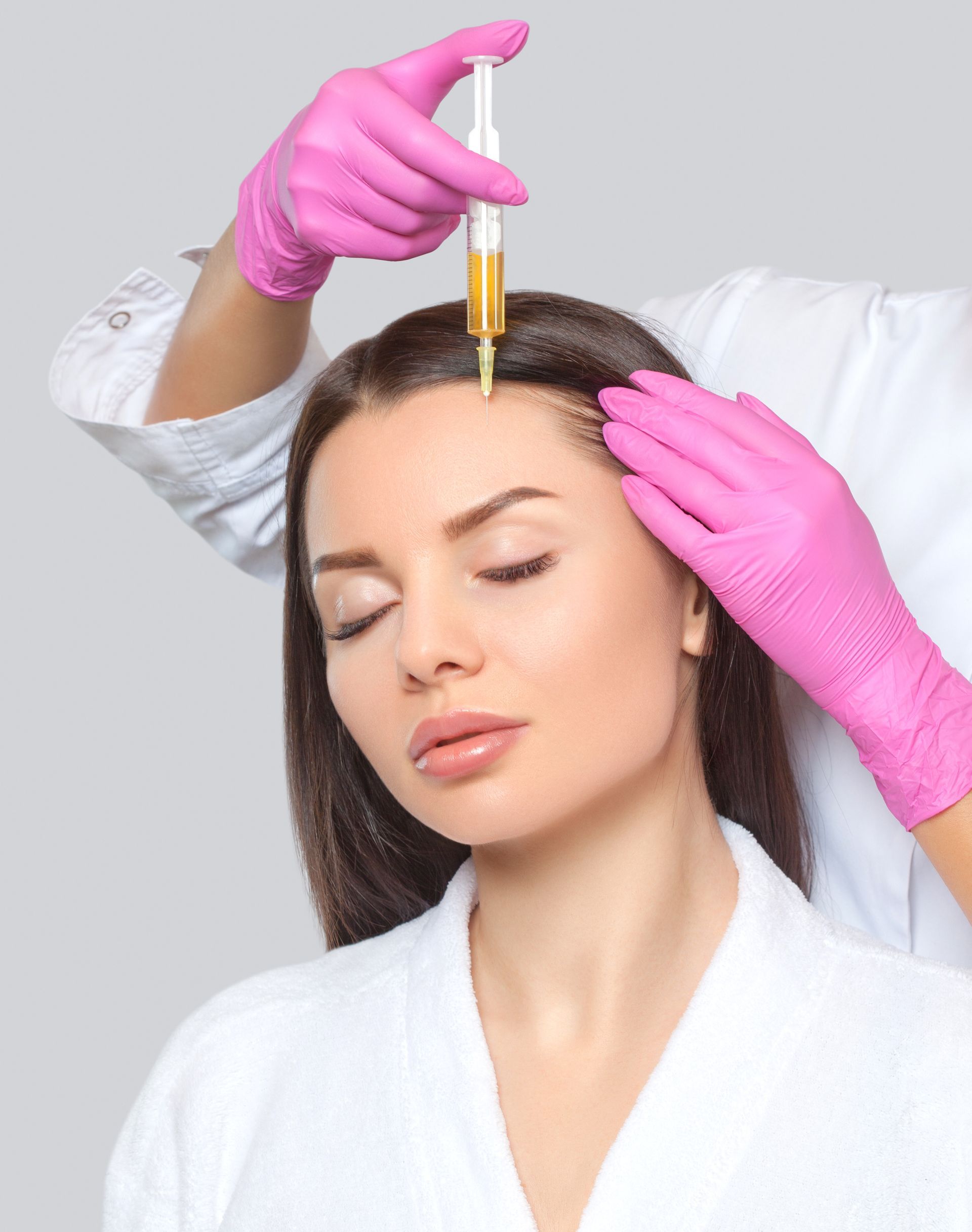 A woman is getting a botox injection in her head.