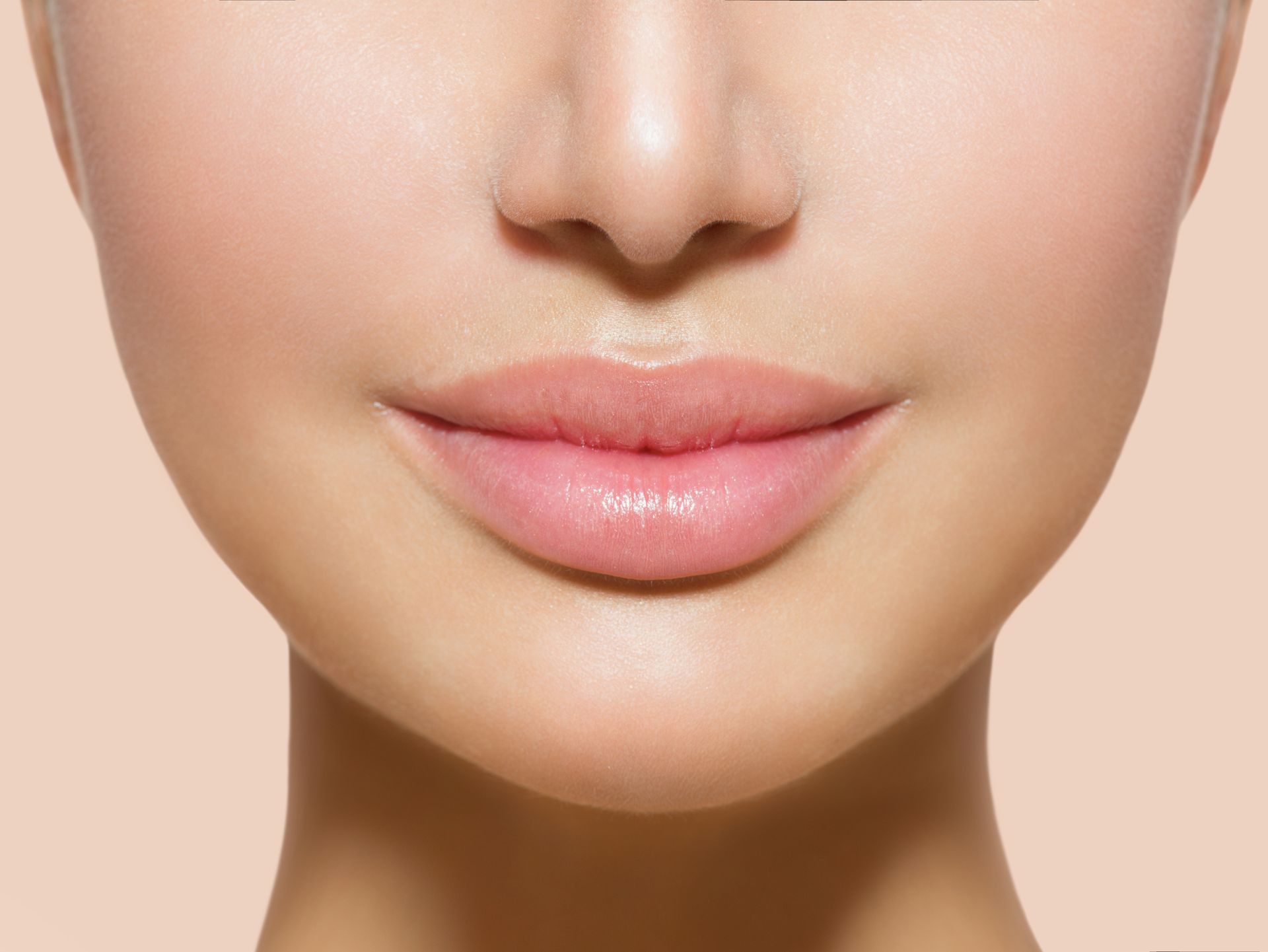 a close up of a woman 's face with pink lips .