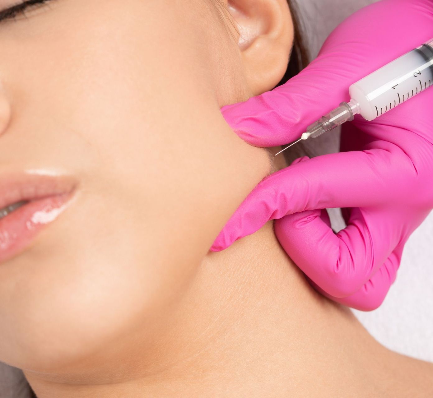 a woman is getting a botox injection in her neck .