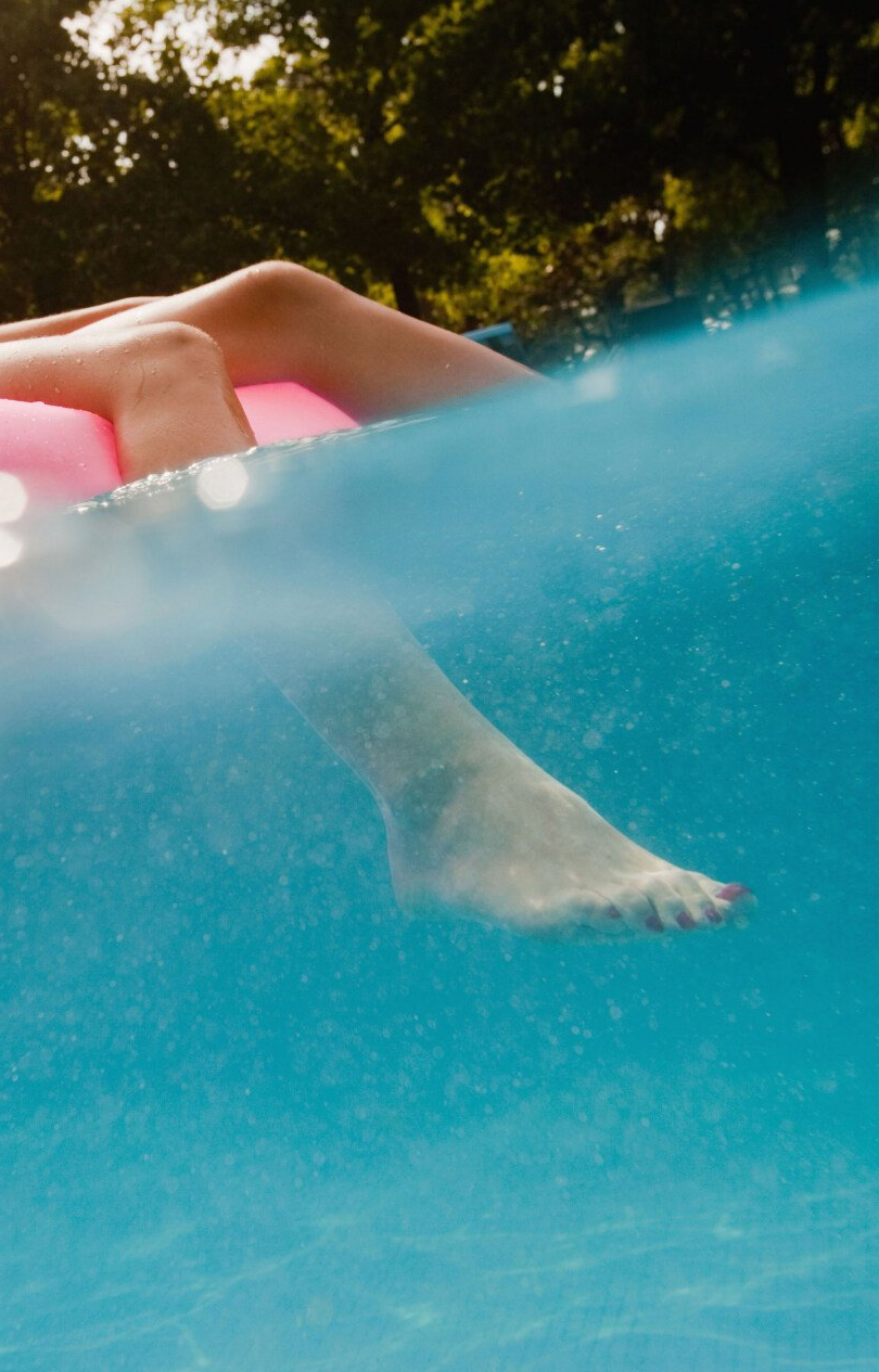 a teenager chilling on a tube in a pool