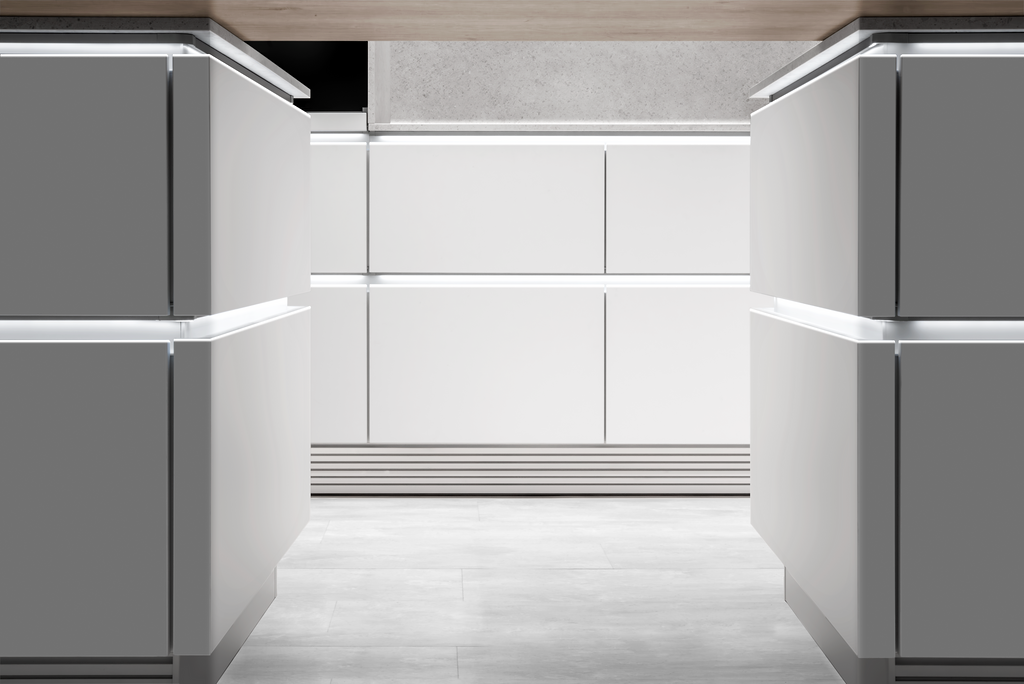 A modern, minimalist kitchen with white cabinets and integrated lighting, featuring clean lines and a light-colored floor.