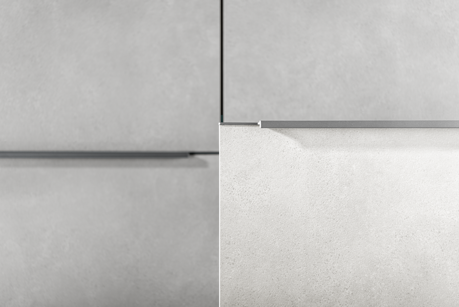 Close-up view of two gray panels with a silver horizontal trim. The lower-right panel has a rougher texture.