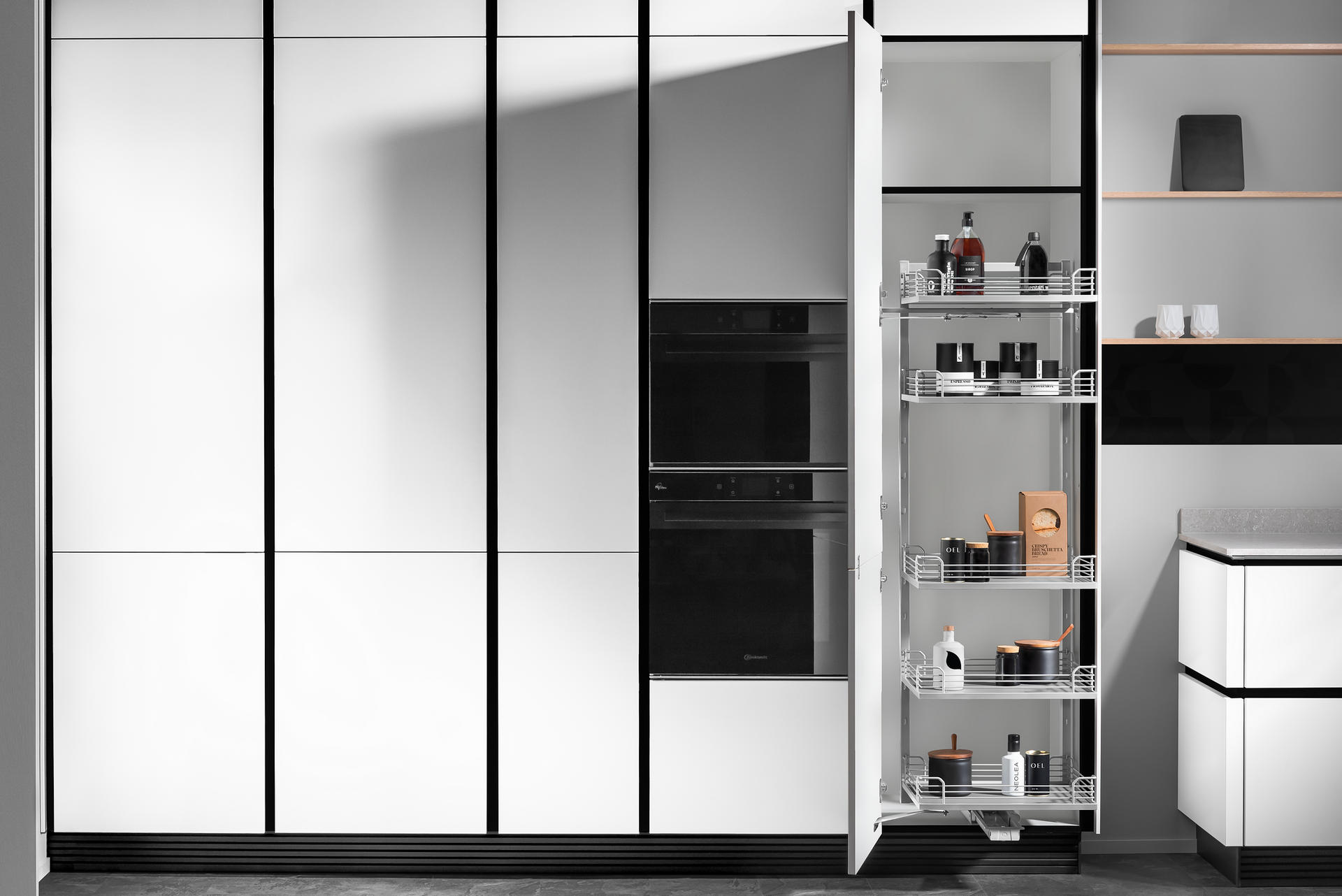 Modern white kitchen pantry cabinet with pull-out shelves, a built-in oven, and various items stored inside.