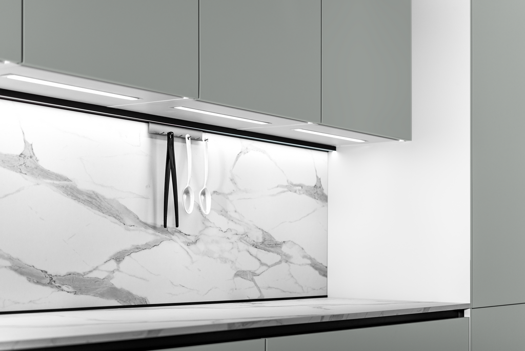 Modern kitchen with gray cabinets, marble backsplash, and under-cabinet lighting illuminating utensils.
