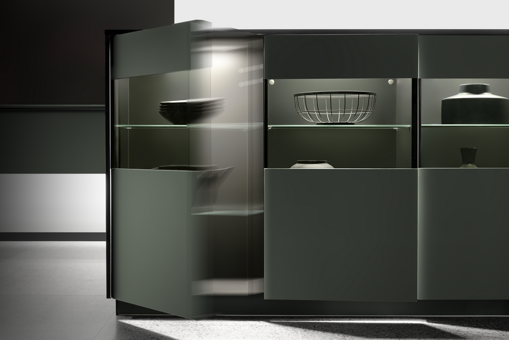 Modern gray cabinet with glass shelves and objects illuminated with interior lighting. One door is slightly ajar.