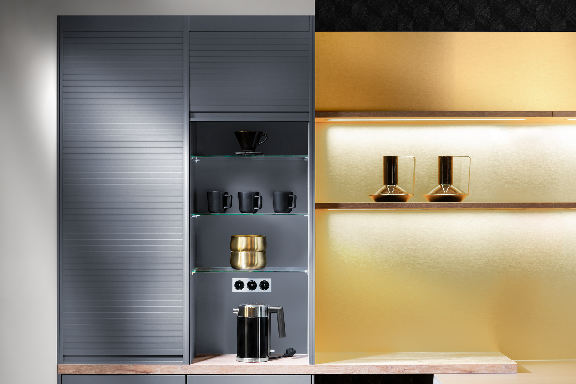 Kitchen cabinet with a gray, horizontally lined door. A built-in open shelving unit displays mugs, decorative items, and a coffee maker. Illuminated gold background.