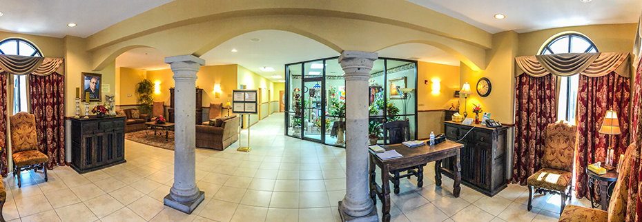 Person typing on a laptop with a leather notebook nearby. Gray blazer, selective focus.