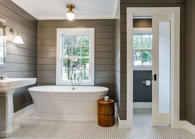 Hamptons-style bathroom in Cremorne with timber panelling, a freestanding tub, and a soft natural light aesthetic.