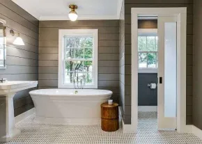 Hamptons-style bathroom in Cremorne with timber panelling, a freestanding tub, and a soft natural light aesthetic.