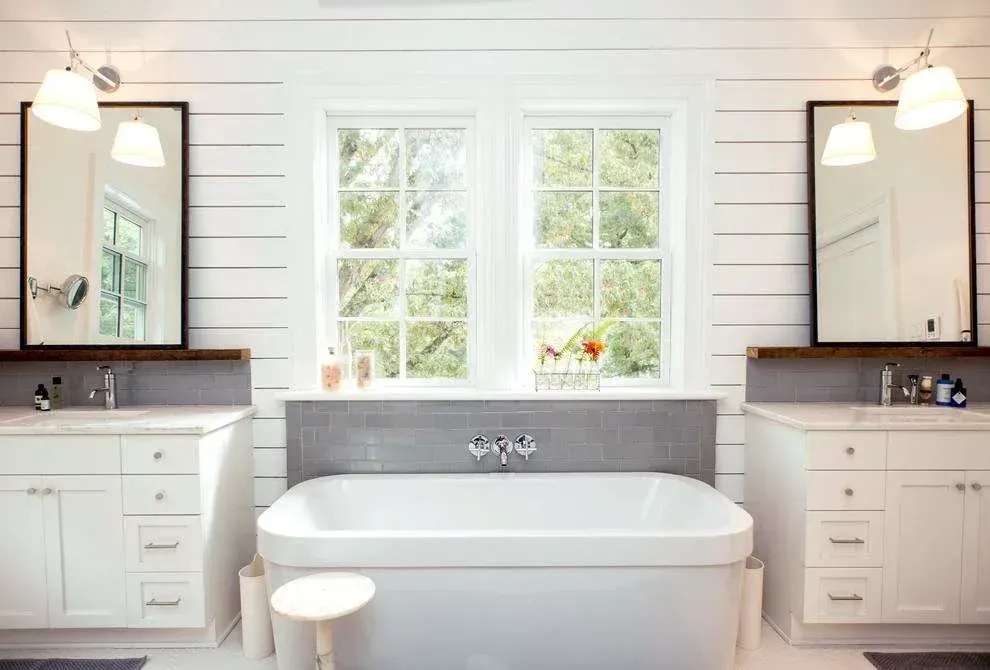 Elegant freestanding bathtub with shaker-style cabinetry and twin windows — part of a Roseville ensuite renovation.