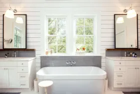 Elegant freestanding bathtub with shaker-style cabinetry and twin windows — part of a Roseville ensuite renovation.