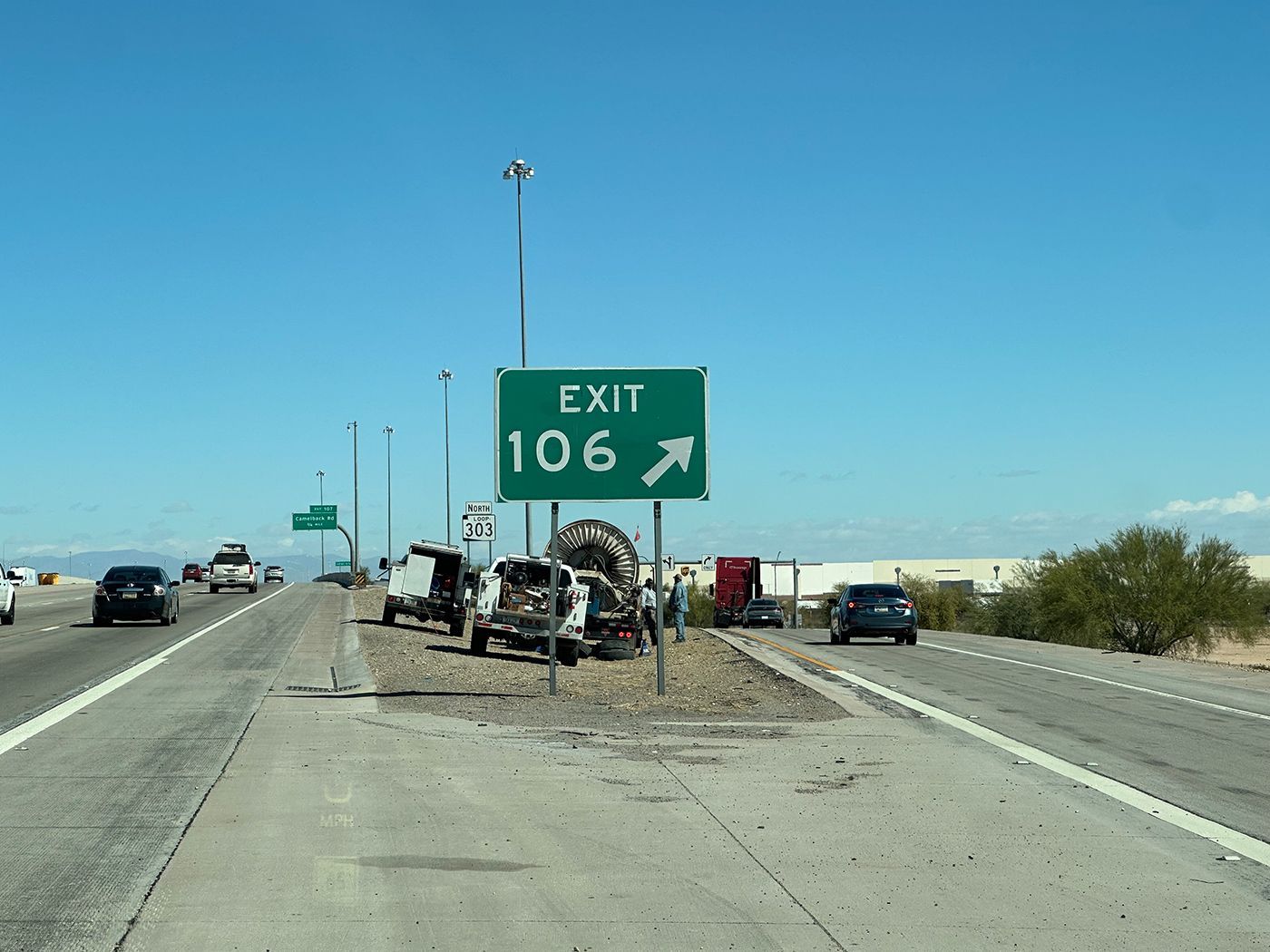A green exit sign on the side of a highway