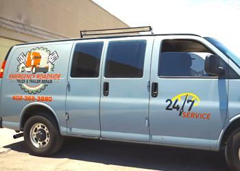 a 24/7 service van is parked in front of a building