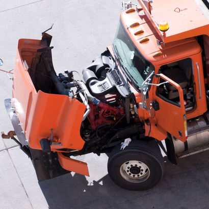 a red semi truck and a white semi truck are driving down a road .