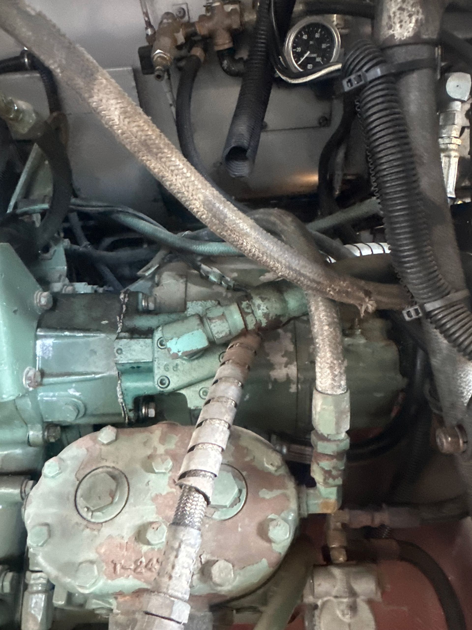 Engine components with hoses and fittings, painted in teal, with various metal parts.