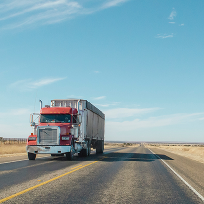a white semi truck with its hood open is parked in a parking lot .