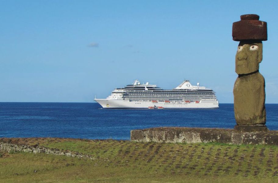 cruise ship in the water with statue in the foreground A cruise ship is floating in the ocean next to a statue.