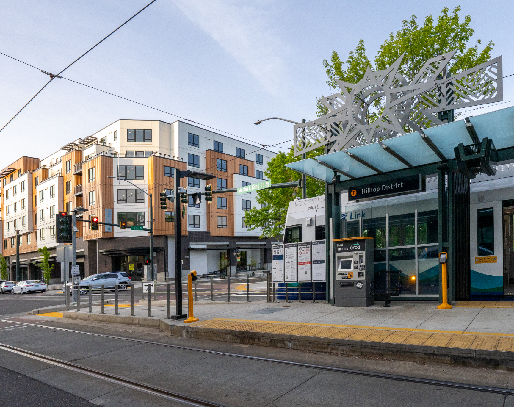A man is waiting for a bus at a bus stop at night.