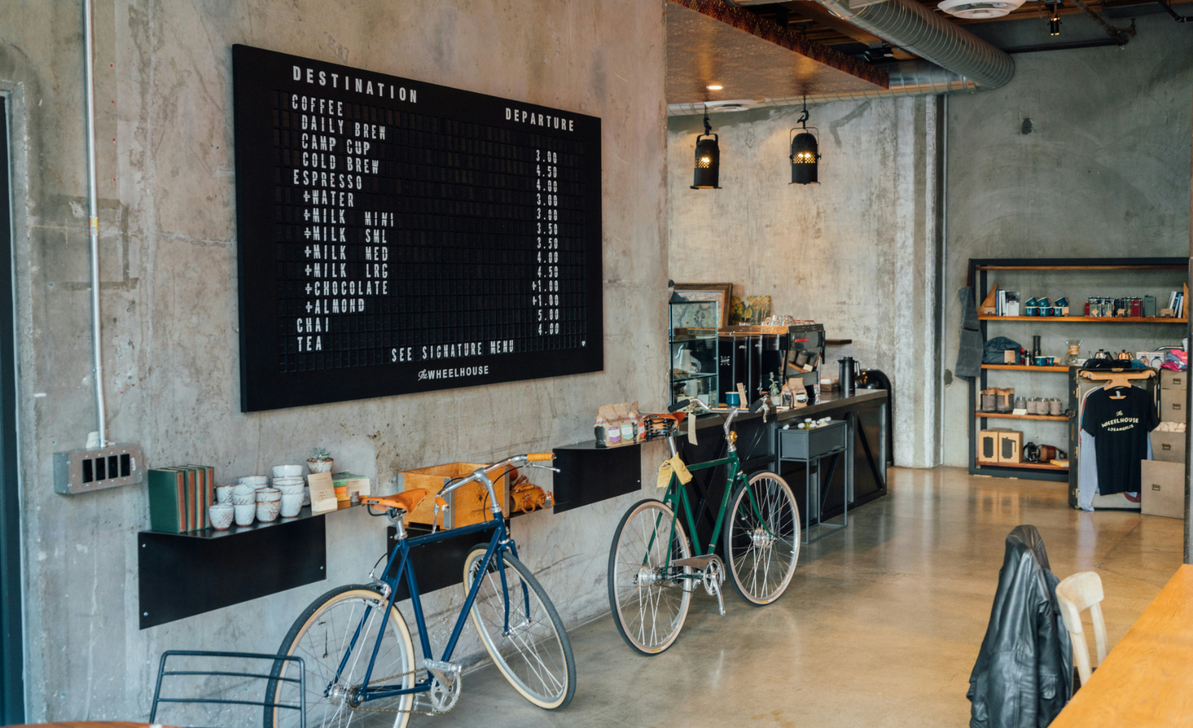 Coffee shop interior with menu board, bicycles, and bar.