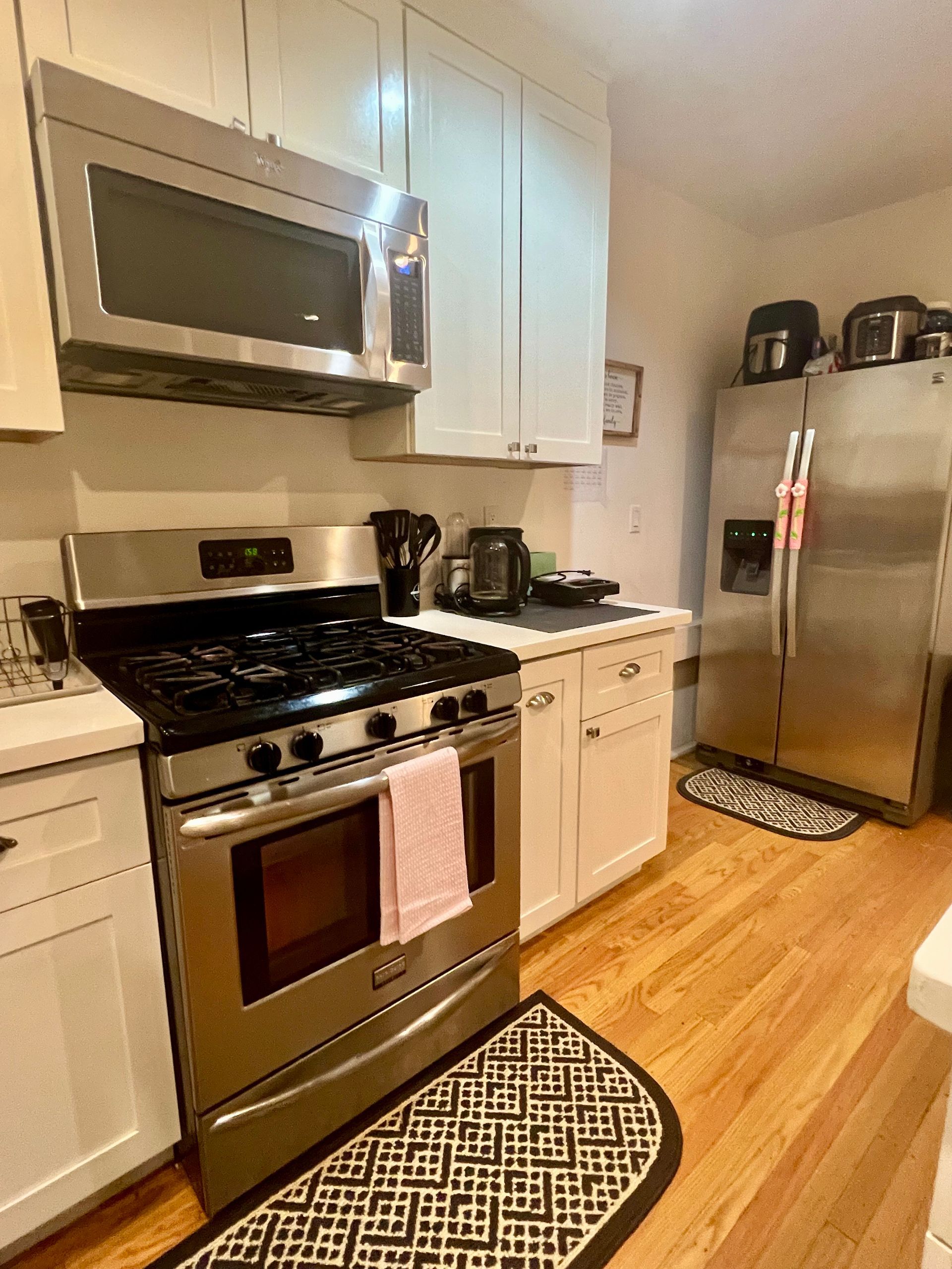 A kitchen with a stove , microwave and refrigerator
