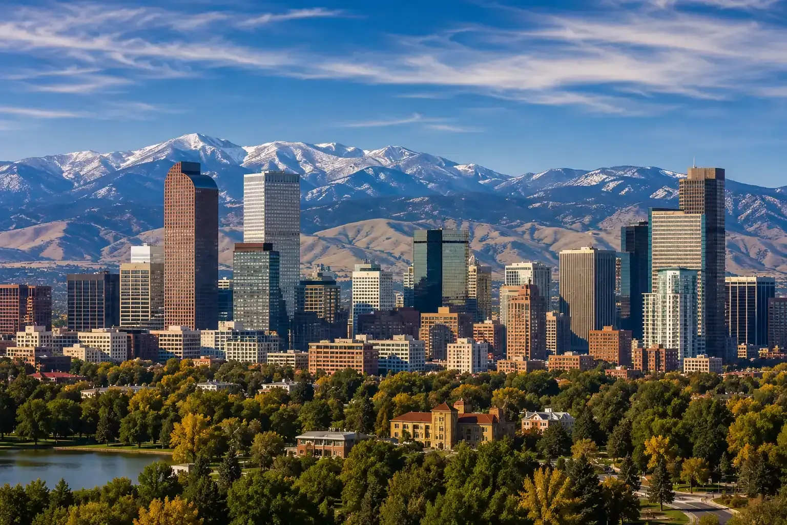 Denver skyline with skyscrapers and snow-capped mountains under a clear blue sky